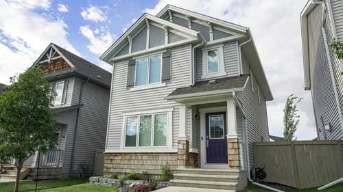 Contemporary suburban home with a front porch and clear blue sky, ideal for real estate themes.
