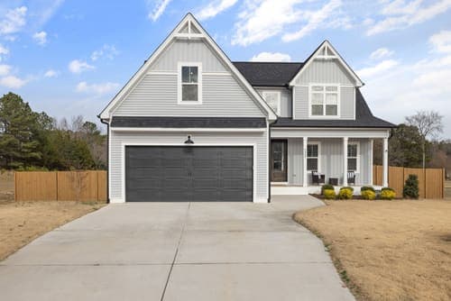 A modern two-story suburban house with a large driveway and garage.